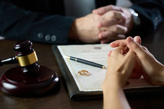 Female lawyer explaining the will to senior woman. Close up of hands, unrecognizable people.